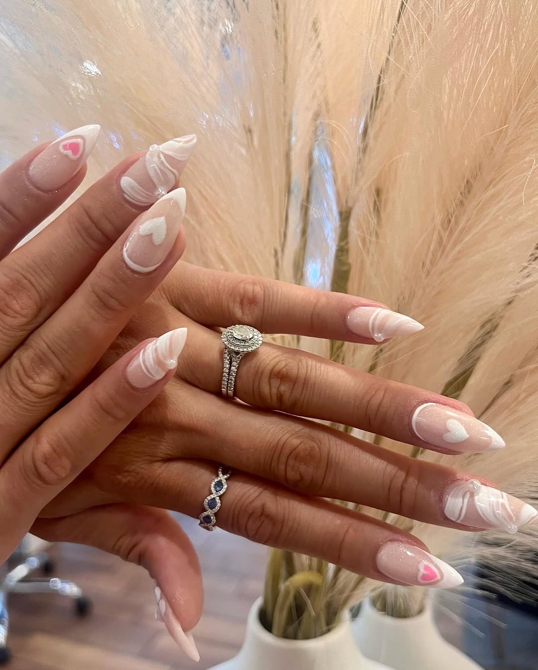 Nude French tip nails with fine linework and pink heart accents