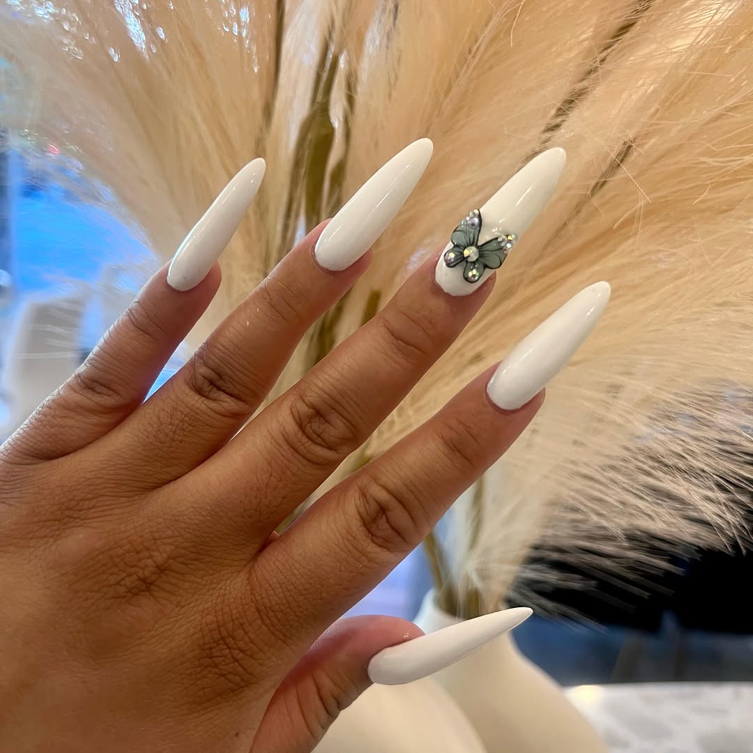 Glossy white almond nails with a 3D butterfly accent nail