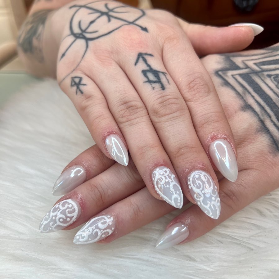 Milky-white chrome almond nails with fine lace nail art