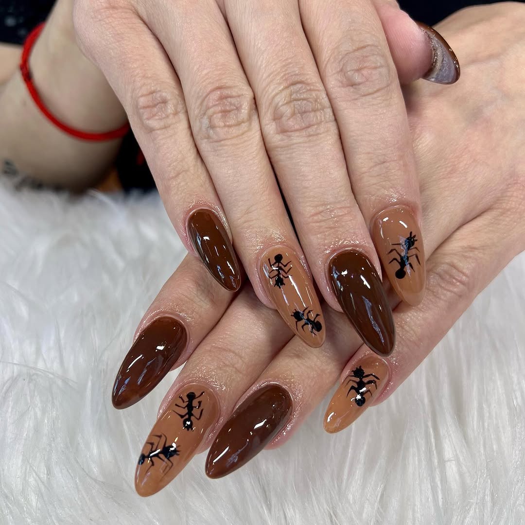 Chocolate-brown glossy almond nails with a hand-drawn novelty design